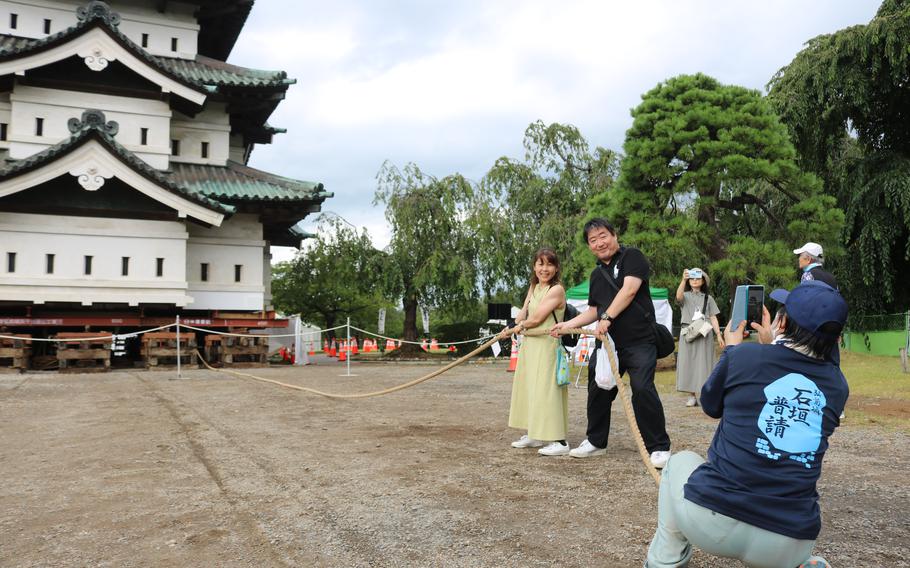 A cameraman poses for a photo of a couple pulling the castle.